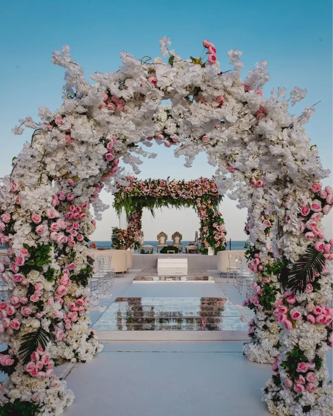 Romantic beachside wedding ceremony with floral arch
