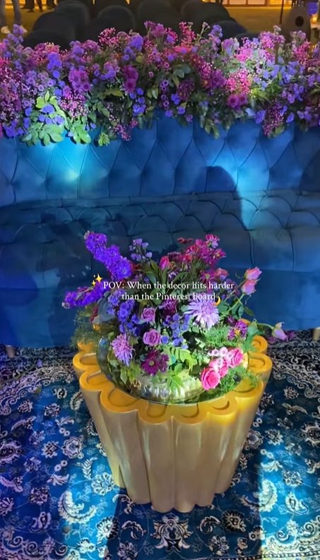 Purple floral arrangement with blue velvet sofa by Revaah Decor
